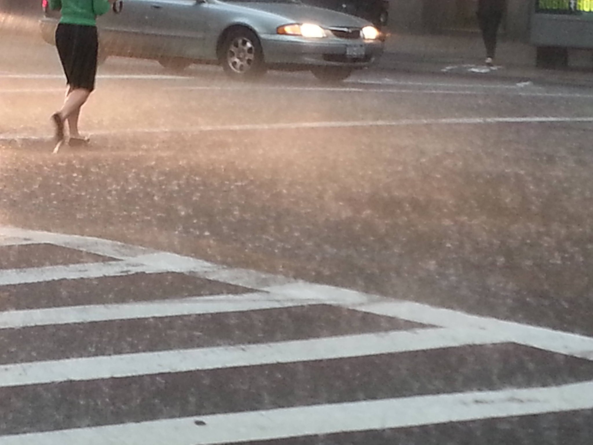 Woman with umbrella crossing a rainy street